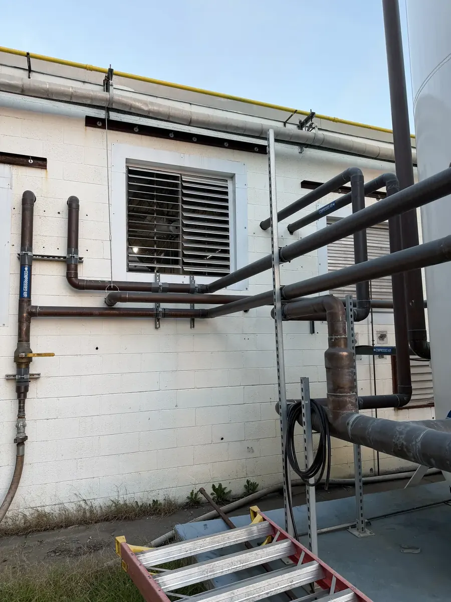 Compressed air piping run along the outside of the building by CDS