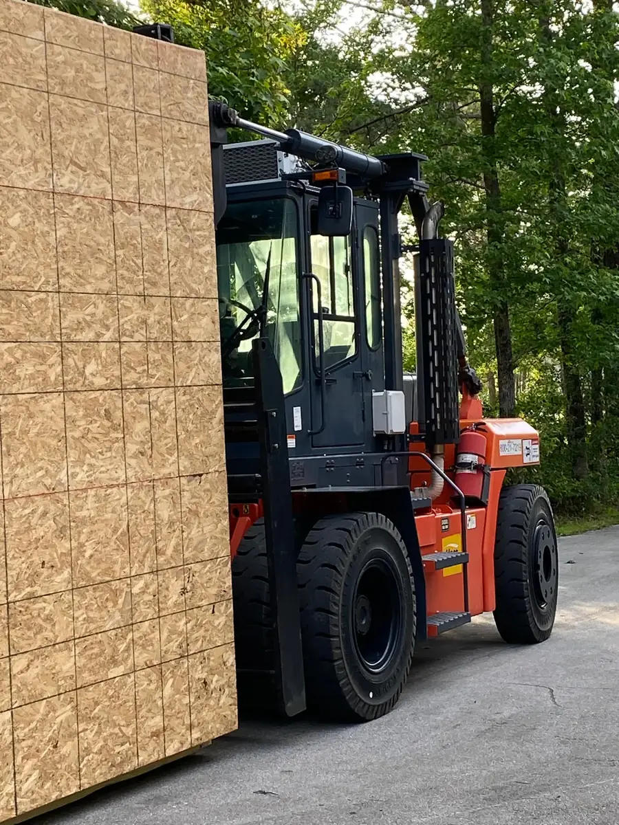 Forklift carrying a large crated machine