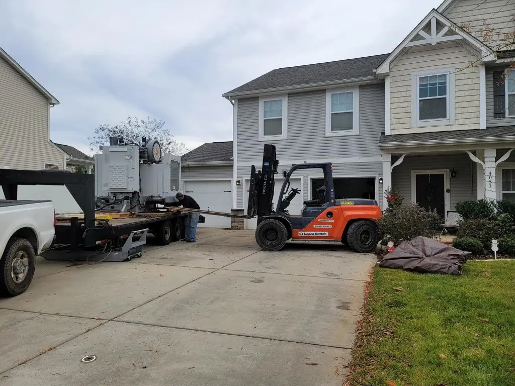 Forklift delivering a standby generator to a home