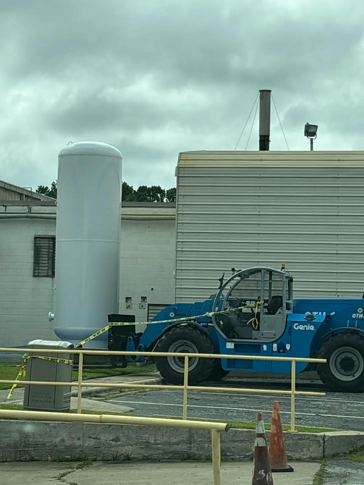 Telehandler moving a large tank at an industrial site